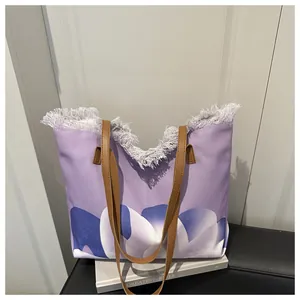 Detalle del bolso de lona morado con flecos y correas de cuero en la exhibición