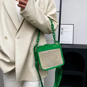 Detail of green leather stitching and woven straw texture on fashion crossbody bag