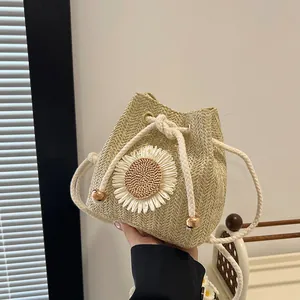 Handwoven straw bucket bag with sunflower decor and white drawstring closure
