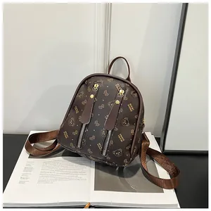 Detail of mini brown backpack with Moni Xiong pattern and vertical zipper pockets
