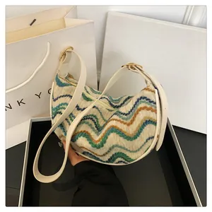 Detailed view of colorful wavy knit pattern and white leather straps with golden buckles