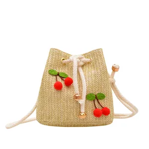 Handwoven straw bucket bag with red cherry accents and white rope straps