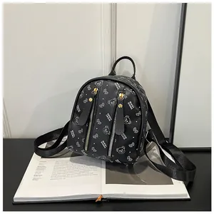 Detail of black mini backpack with bear monogram print and golden metal zippers