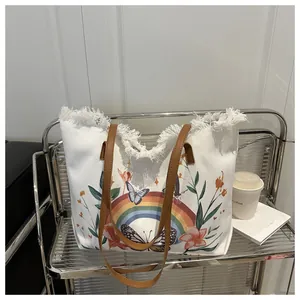 Detail der weißen Canvas-Tasche mit Schmetterlings-Regenbogen-Print und Ledergriffen