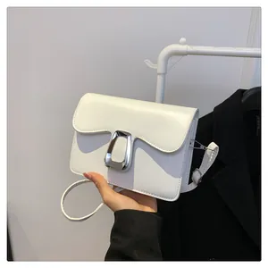 Detail view of white PU leather crossbody bag with silver D-ring buckle and wavy flap design