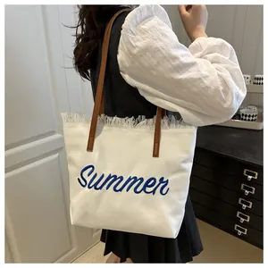 Vista lifestyle della borsa tote in tela con ricamo Summer e tracolla in pelle marrone