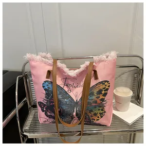Detail der rosa Canvas-Einkaufstasche mit Schmetterlingsdruck und modischen Fransen