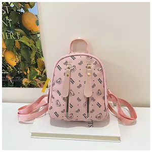 Detail showing pink mini backpack with bear pattern and metal zipper pockets
