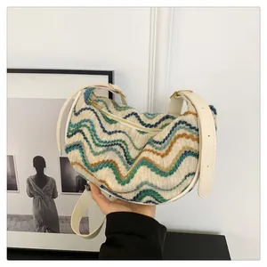 Detail of colorful wavy pattern on cream knitted shoulder bag with gold hardware