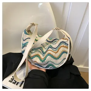 Detail of colorful knitted wave pattern and white leather trim on the shoulder bag