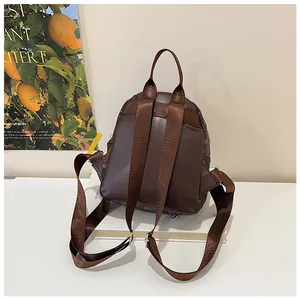 Detail of a brown mini backpack back with adjustable nylon straps and faux leather texture
