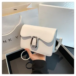Close-up of white leather square bag featuring a signature silver irregular metal buckle