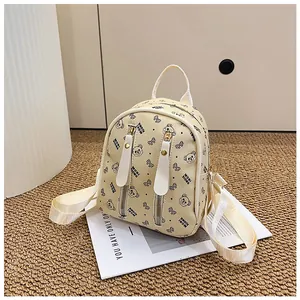 Detail of cream mini backpack with cartoon bear prints and double zipper front pockets