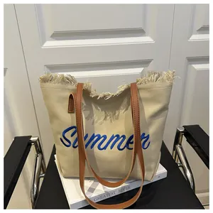 Ricamo dettagliato del logo Summer su borsa tote in tela beige con bordo a frange