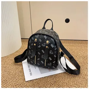 Detail of black mini backpack with cartoon bear prints and golden zipper accents
