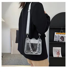 Borsa a tracolla trasparente in PVC con bordi diamantati e catena indossata da modella