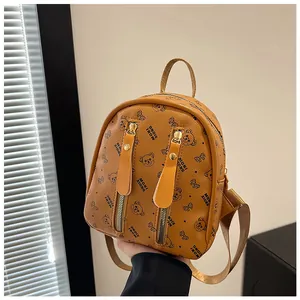 Close-up of orange PU leather mini backpack with black bear pattern and dual front pockets