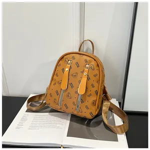 Detail of mini backpack featuring bear print pattern and vertical metal zippers