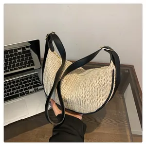 Detail of woven half-moon bag featuring V-shaped texture and black leather strap