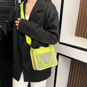 Detail of woven straw crossbody bag with neon leather flap and chunky resin chain strap