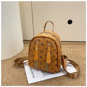 Close-up of mini backpack with bear patterns, dual zippers, and top handle detail