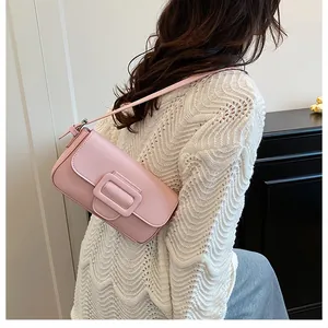Detailed side view of a pink matte leather baguette bag with square buckle on a model