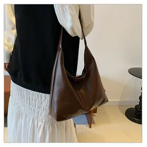 Detail of soft dark brown leather tote bag with a spacious interior and retro hobo design
