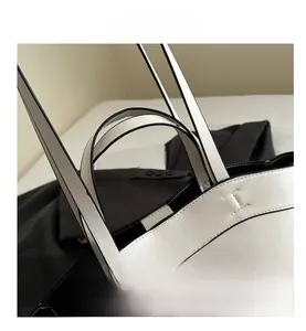 Close-up of contrast stitching and reinforced handles on the black and white tote bag