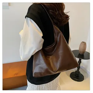 Detail of soft dark brown synthetic leather hobo bag showing texture and glossy finish