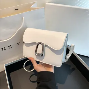 Minimalist white square flap bag in plain PU leather with silver metal buckle on a shoulder strap
