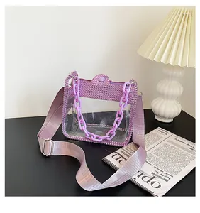 Dettaglio borsa in PVC viola trasparente con bordi di strass e catena in plastica