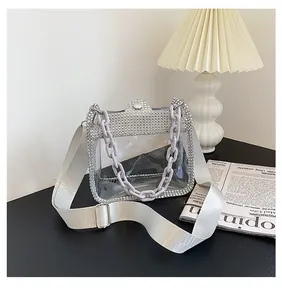 Dettaglio borsa a tracolla in PVC trasparente con bordi in strass e catena decorativa viola