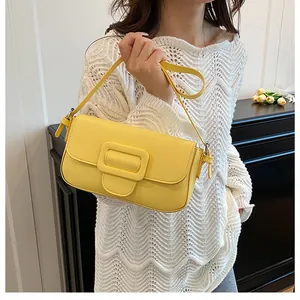 Detailed view of a bright yellow rectangular shoulder bag with a large matching square buckle