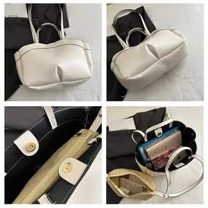 Detail view of cream tote bag features magnetic clasp and removable inner pouch