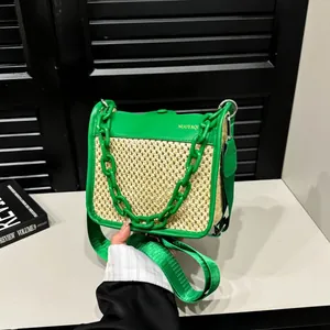Close-up of green leather trim and woven straw texture with gold branding and chain