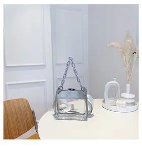 Dettaglio macro di una borsa in PVC trasparente con bordi in strass e catena viola fashion