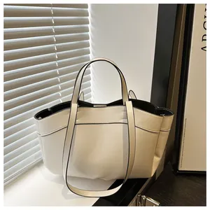 Detail of minimalist tote bag showing black contrast stitching and smooth leather texture
