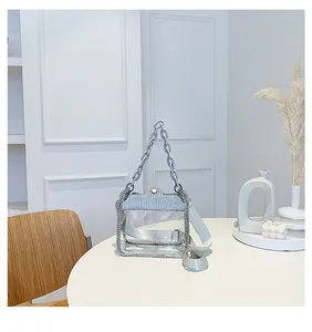 Dettaglio borsa trasparente in PVC con bordo in strass e manico a catena viola