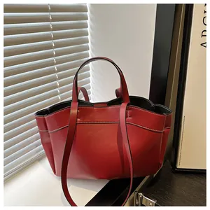 Close-up of a retro dark red tote bag with distinct white contrast stitching details