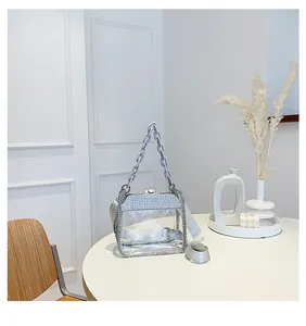 Dettaglio della borsa in PVC trasparente con strass e manico a catena viola scuro