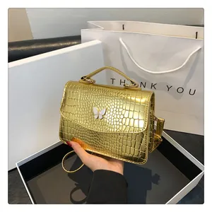 Golden crocodile texture handbag in a gift box with a white butterfly ornament