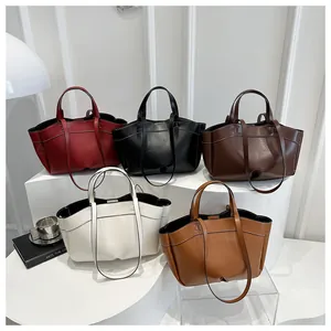 Collection of retro leather tote bags in burgundy, black, cream, and brown on display