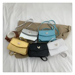 Detail shot of mini butterfly buckle bags in various colors with crocodile texture