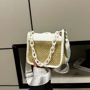 Detailed view of woven straw texture combined with white leather and thick chain strap