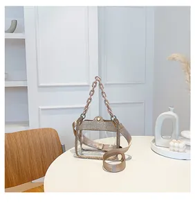 Dettaglio borsa trasparente in PVC con strass, manico a catena e ampia tracolla