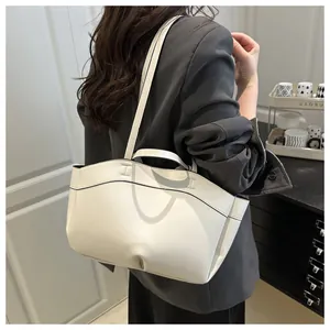 Minimalist white leather tote bag with black piping shown as a stylish shoulder bag