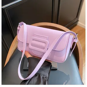 Close-up of a light purple baguette shoulder bag with a square buckle on a wooden chair