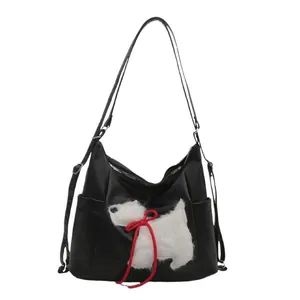 Minimalist black PU leather tote bag with a cute white puppy plush and red bow decoration