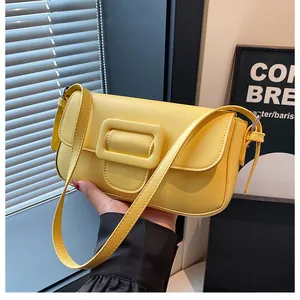 Detail shot of a bright yellow rectangular baguette bag with a large square buckle