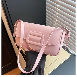 Close-up of pink minimalist handbag featuring a large wrapped square buckle detail